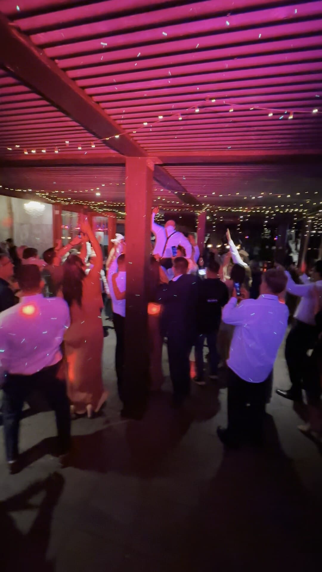 The dancefloor under the fairy-lit pavilion, washed in deep red as the night peaks