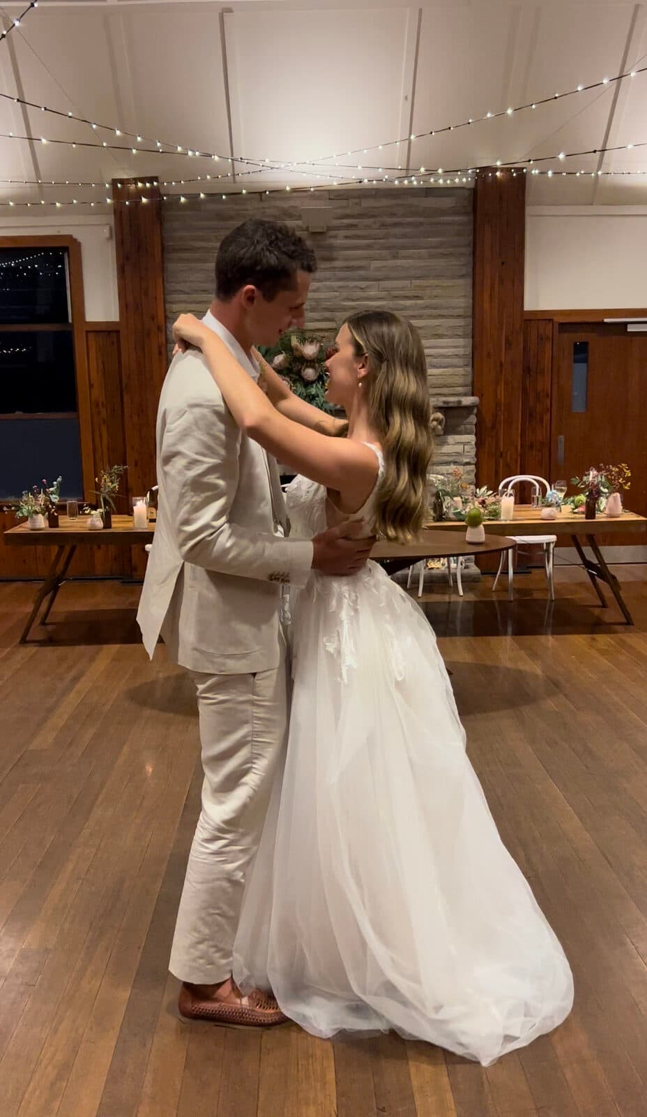 Intimate first dance embrace in rustic hall
