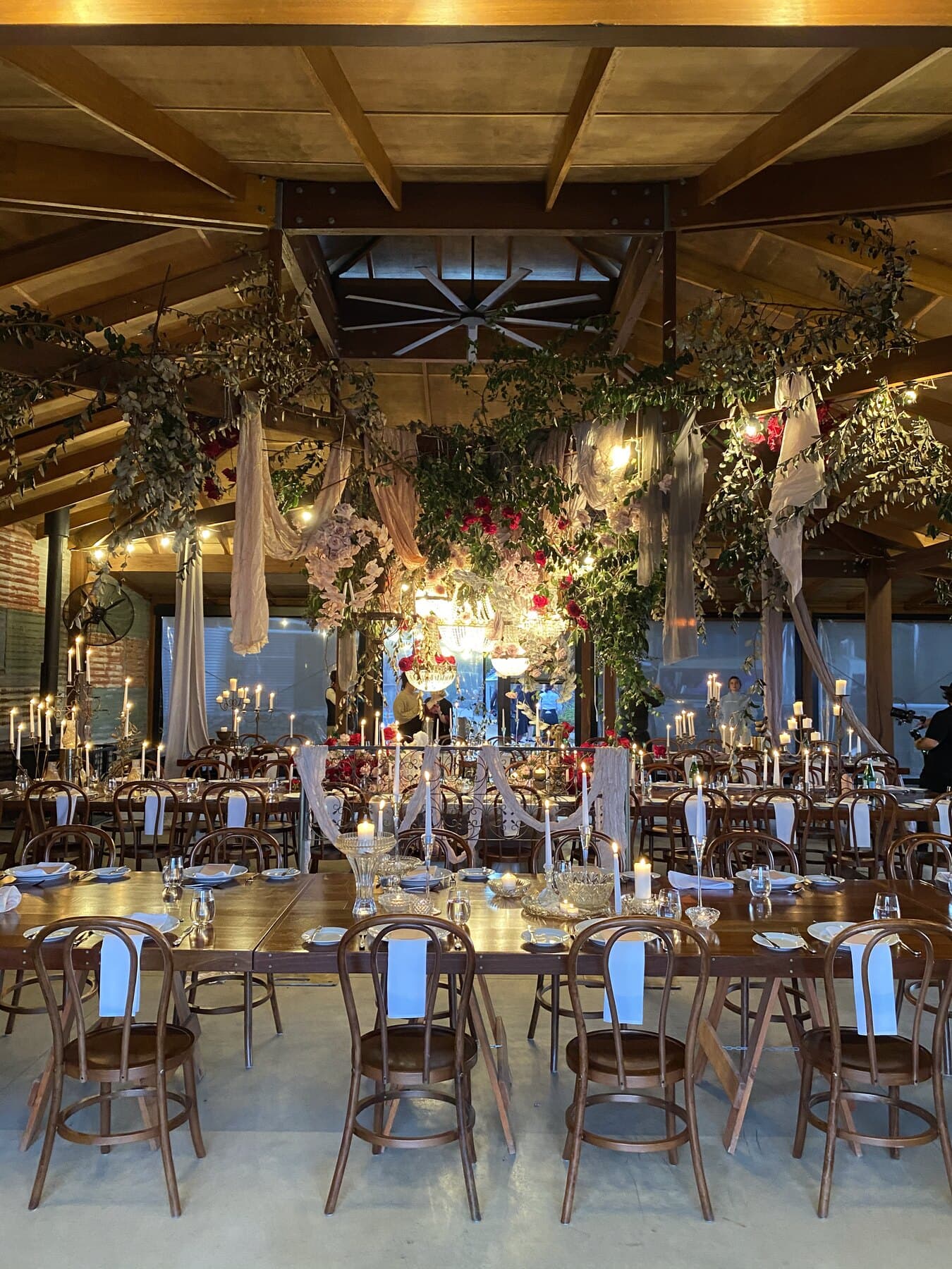 The reception barn dressed with floral installations and a long candlelit table